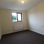 Small empty room with beige walls and window.