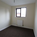 Small empty room with window and radiator.