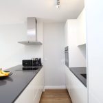 Modern kitchen with sleek white cabinets and hob