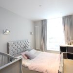 Modern bedroom with crib and grey decor