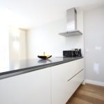 Modern kitchen with white cabinets and appliances.