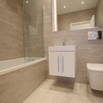 Modern bathroom with tub, sink, and toilet.