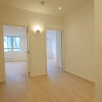 Spacious modern hallway with wooden flooring.
