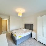 Modern bedroom with bed, wardrobe, and soft lighting.