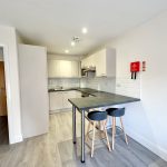 Modern kitchen with breakfast bar and stools.