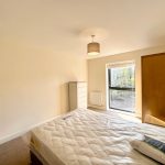 Bright bedroom with bed, wardrobe, and window view.