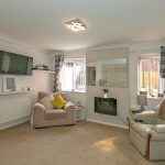 Cosy living room with armchairs and TV.