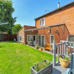 Brick house with garden and seating area.