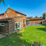 Brick house with spacious garden and patio area.