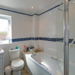 Modern white bathroom with blue tile accents.