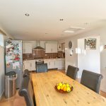 Modern kitchen with dining table and fruit bowl.