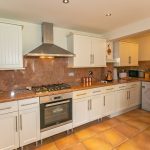 Modern kitchen with white cabinets and appliances.