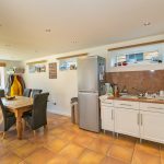 Bright kitchen dining area with fridge and table