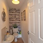 Stylish bathroom with plant, sink, and framed pictures.