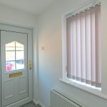 White door and window with vertical blinds.