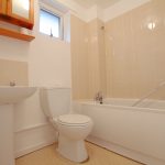 Modern bathroom with bath, toilet, and sink.