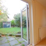 Open door to a green garden view.