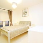 Minimalist bedroom with double bed and natural lighting.