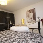 Modern bedroom with patterned bedspread and artwork