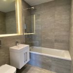 Modern bathroom with illuminated mirror and shower