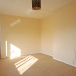 Empty room with beige walls and carpeted floor.