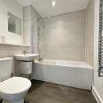 Modern bathroom with bathtub, sink, and toilet.