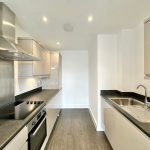 Modern kitchen with sleek countertops and stainless steel appliances.