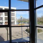 View of buildings and cars through window.