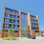 Modern apartment building with parking area.