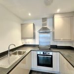 Modern kitchen with stainless steel appliances and counter.