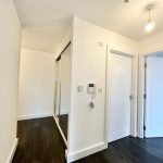 Modern hallway with white doors and dark flooring.