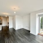 Modern open-plan kitchen and living area with balcony.