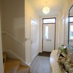 Bright hallway with stairs and modern decor.