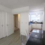 Modern kitchen and dining area with staircase view.