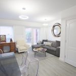 Modern living room with grey sofa and dining table.