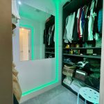Modern wardrobe with LED lighting and shelves.