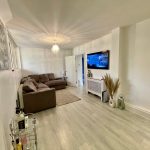 Modern living room with sofa and wall-mounted TV.
