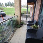 Small balcony with plants overlooking parked car.