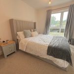 Cosy bedroom with large window and grey decor.