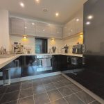 Modern kitchen with dark cabinets and appliances.