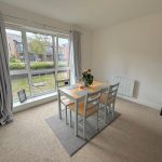 Bright dining room with modern furniture and window view.