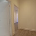 Modern hallway with open doors and wooden floor