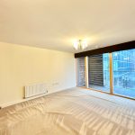 Spacious modern room with large window and balcony view.