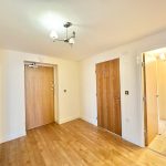 Bright hallway with wooden doors and flooring.