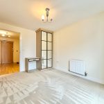 Unfurnished bedroom with wardrobe and study desk.