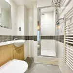 Modern bathroom with shower and heated towel rail.