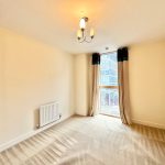Bright empty room with window and chandelier.