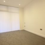 Empty room with beige carpet and white walls.