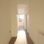 Bright hallway with natural light and wooden flooring.