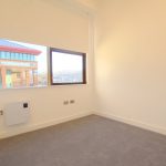 Empty room with window overlooking office building.